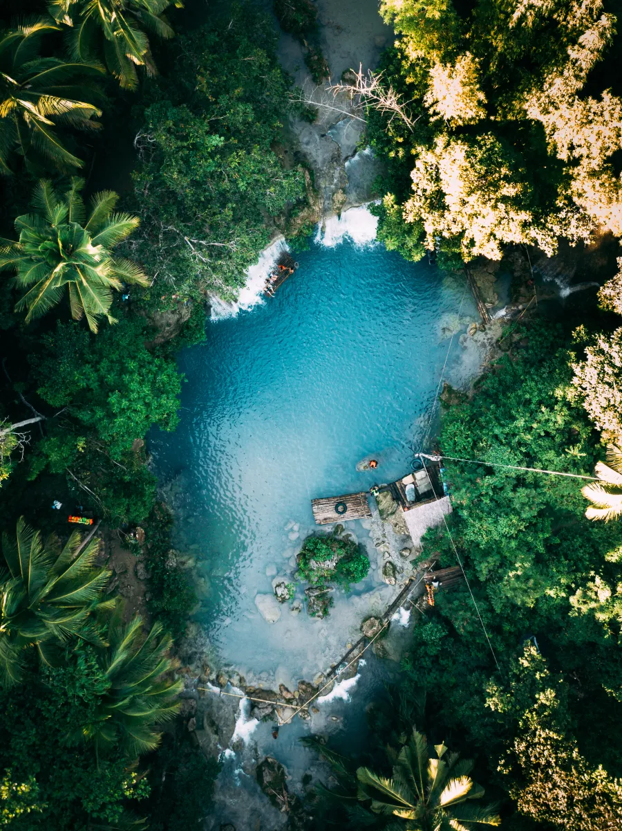 Poza de agua turquesa rodeada de selva, vista desde arriba